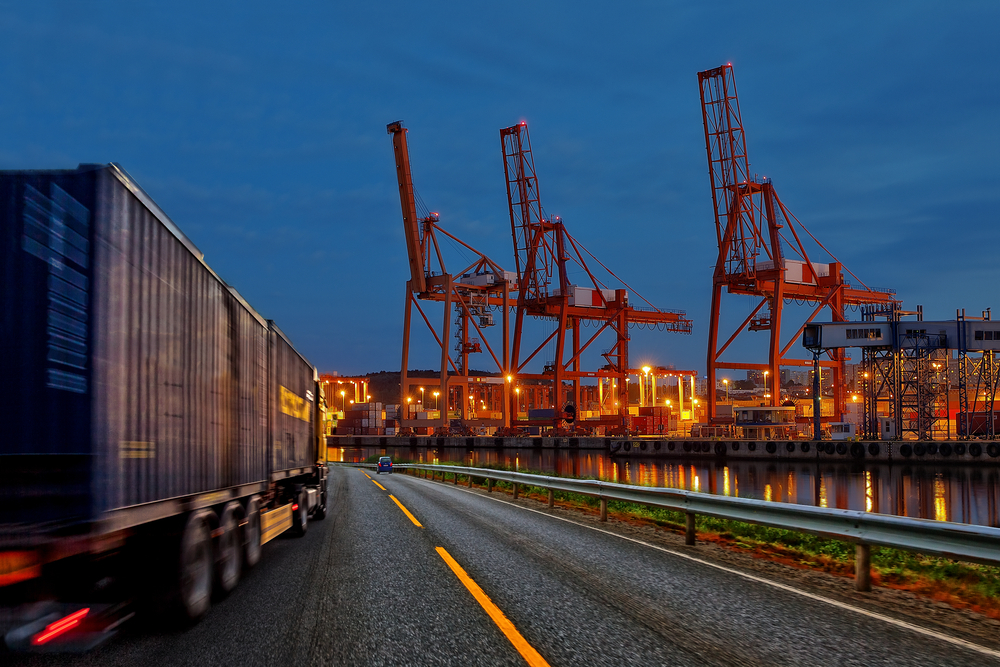 Truck on road facing a marine terminal
