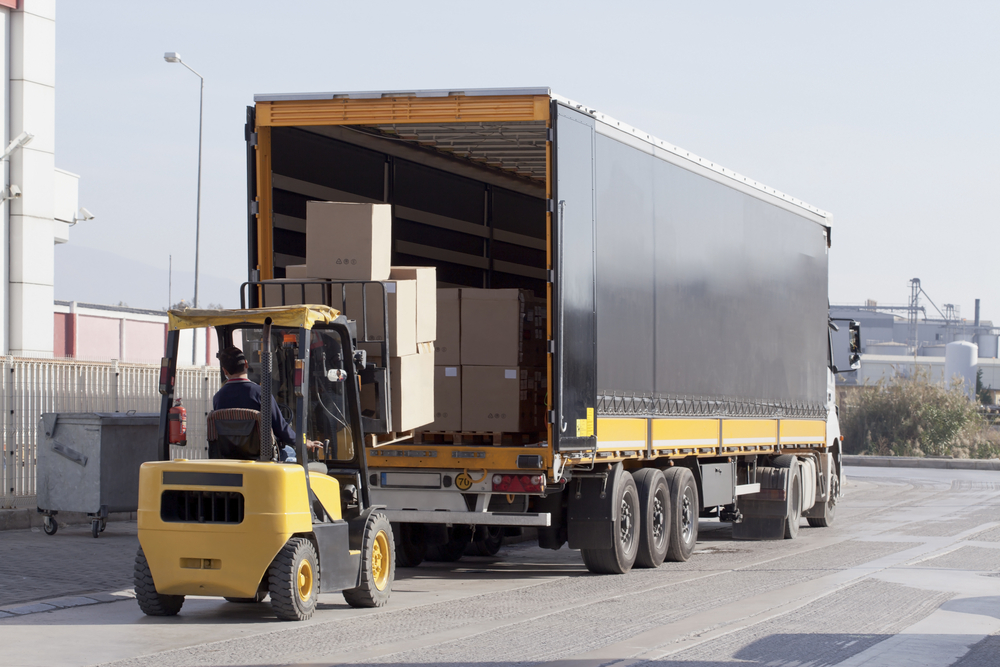 Forklift loading a skid into a truck